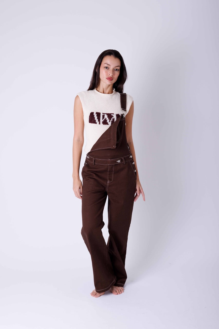 Woman wearing brown oversized dungarees with a knitted top underneath 